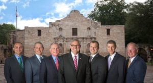 Group photo of doctors with the Alamo as a backdrop